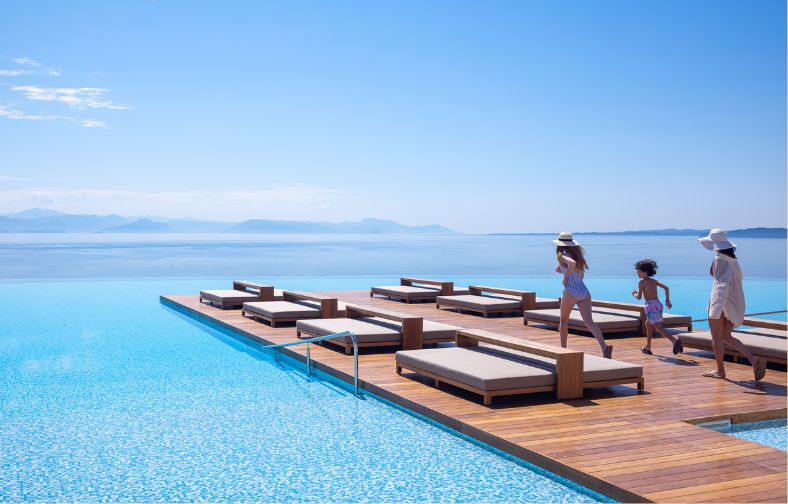 family enjoying summer vacations by the infinity pool villa of angsana corfu 